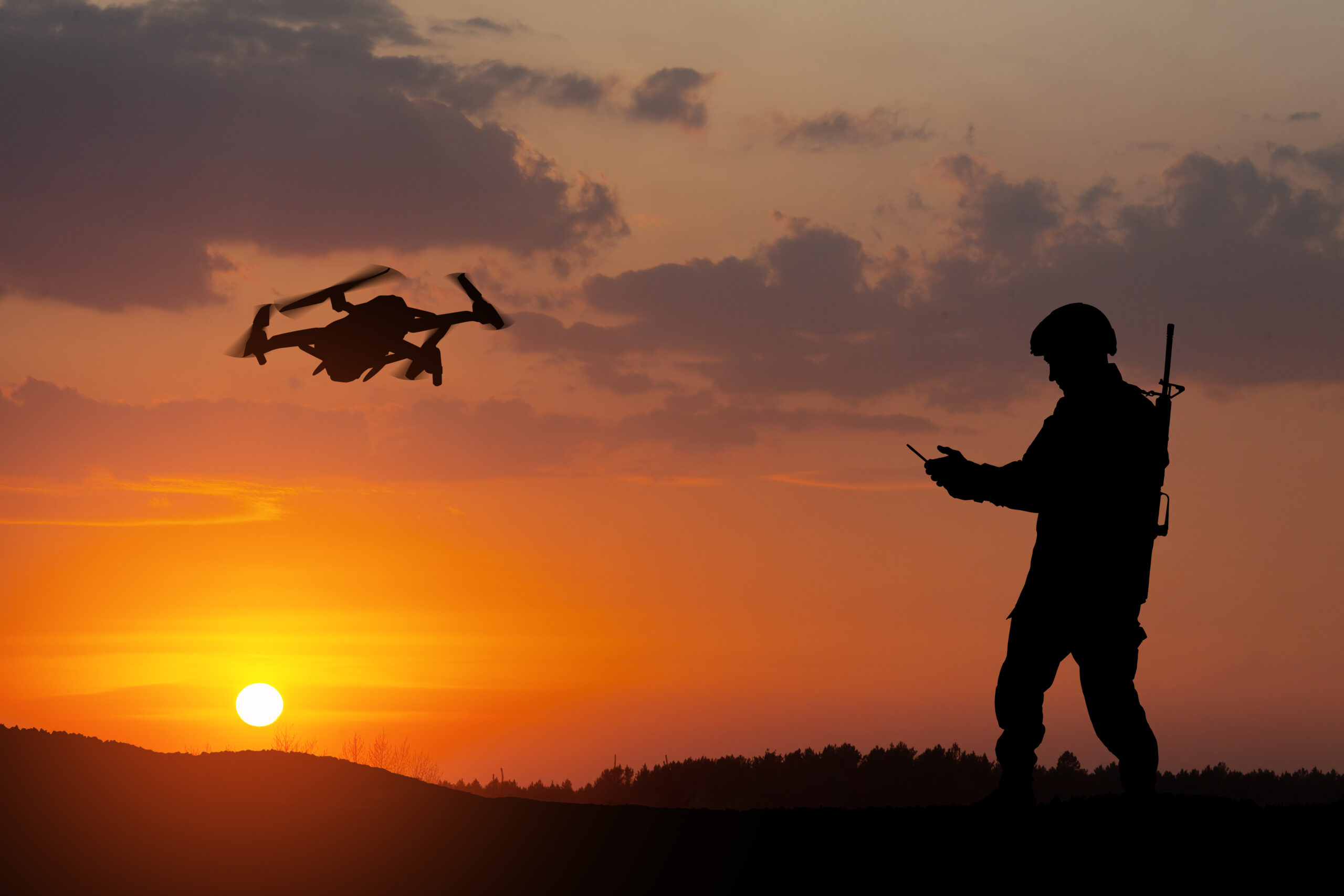 Silhouettes of soldiers are using drone and laptop computer for scouting during military operation.